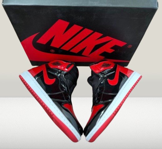 Jordan 1 Patent-Bred shoes under lighting highlighting glossy red accents and black stitching