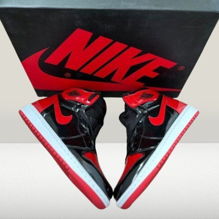 Jordan 1 Patent - Bred [Family] - ShoeResidenceJordan 1 Patent - Bred shoes under lighting highlighting glossy red accents and black stitchingJordan 136adidas patent bredAdidas Tenes Inalta PieleADIDASI JORDANI4